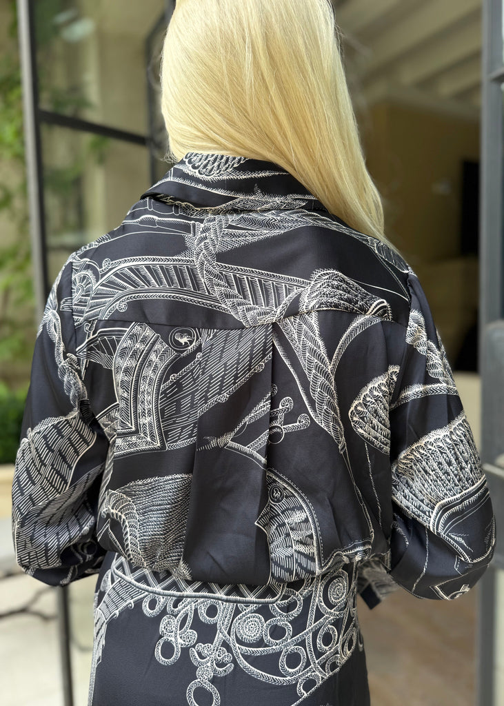 Person wearing a black and white patterned jacket outdoors