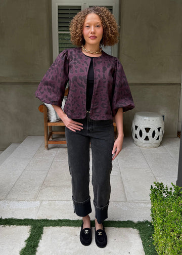 Woman standing on a patio with a neutral background