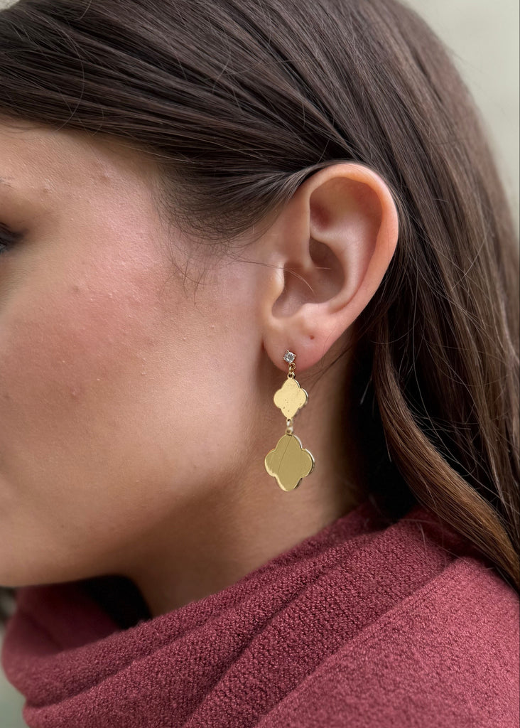 Close-up of a woman wearing gold earrings with a blurred background