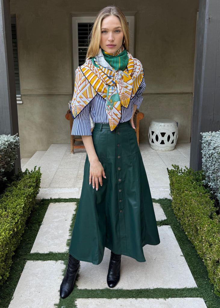 Woman wearing a colorful scarf and green skirt in an outdoor setting