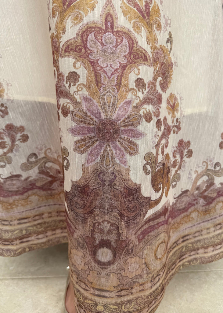 Close-up of patterned fabric with intricate designs in brown, purple, and gold.