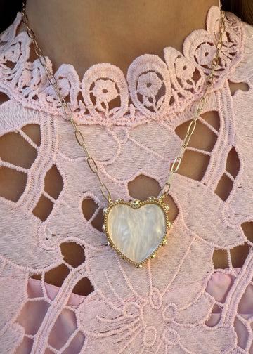 Heart-shaped pendant necklace on a lace garment