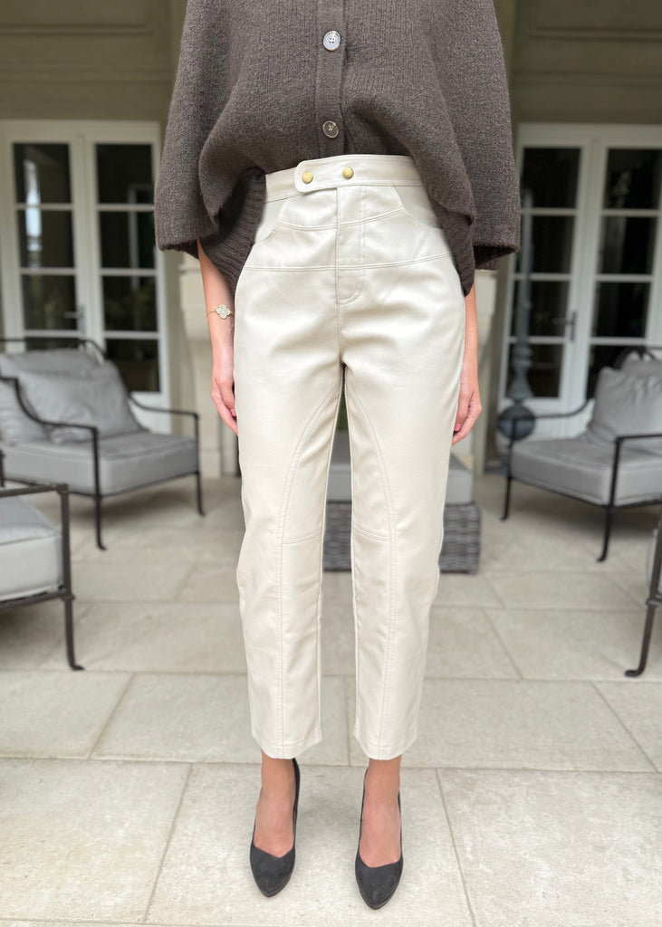 Person wearing beige pants and a brown top in an outdoor setting