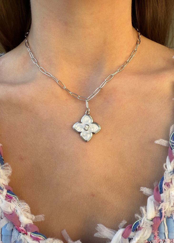 Necklace with a floral pendant worn by a person