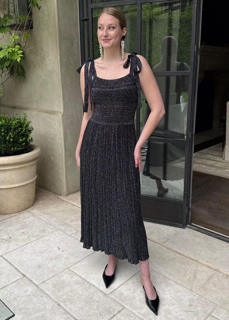 Woman in a black dress standing outside a building