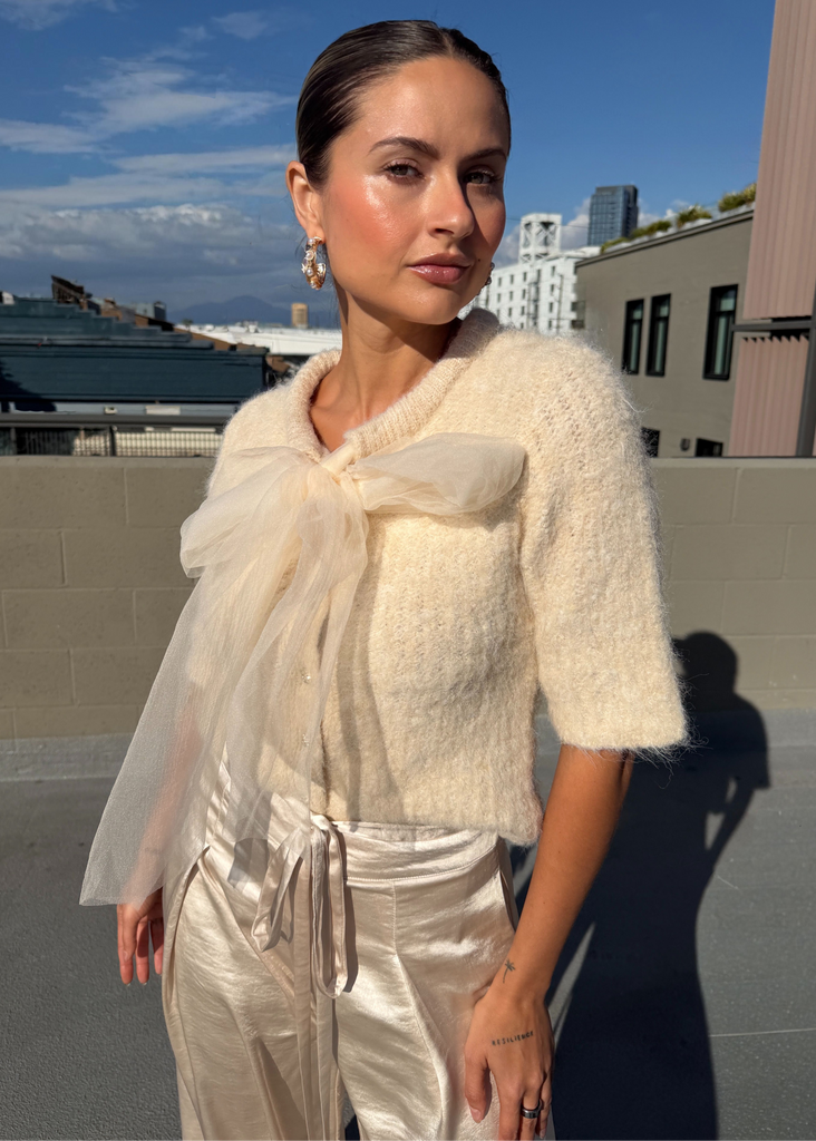 Woman in a stylish outfit with a cityscape in the background