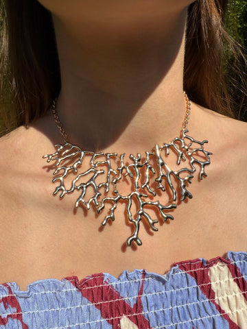 Necklace with a coral reef-like design worn by a person outdoors