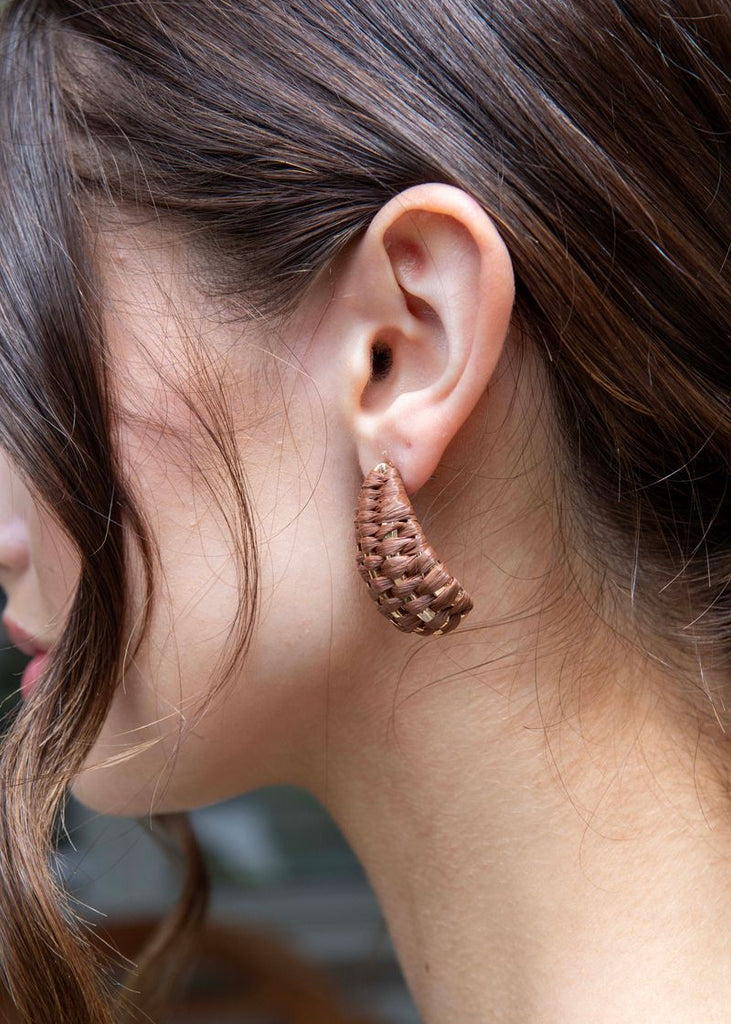 Close-up of a person wearing a textured ear cuff with blurred background