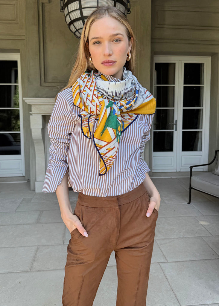 Woman wearing a colorful scarf and standing on a patio