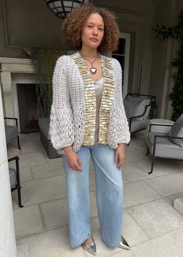 Woman wearing a textured cardigan and jeans in an outdoor setting