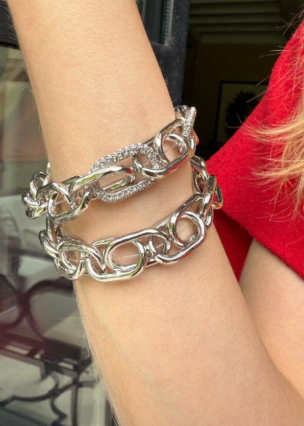 Silver chain bracelet on a wrist with a blurred background