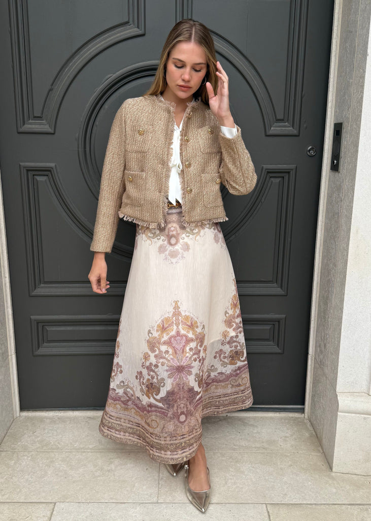 Woman in a stylish outfit standing in front of a dark door.