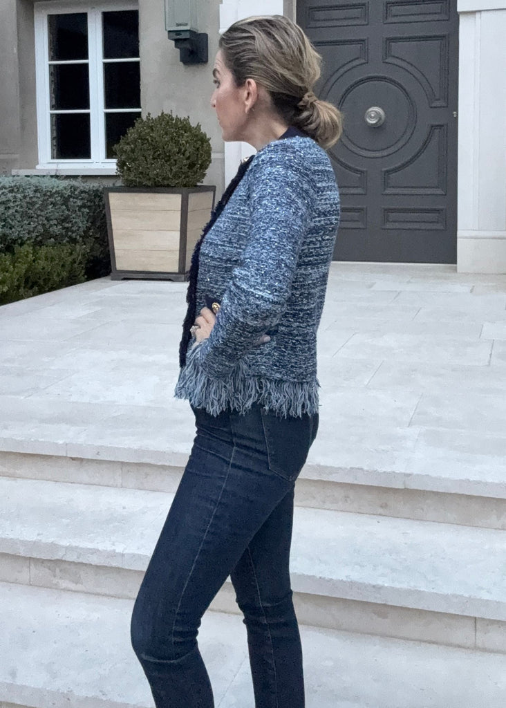 Woman standing in front of a large, ornate door on a building.