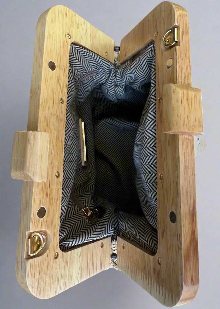 Wooden briefcase with open lid showing black fabric interior on a gray surface.