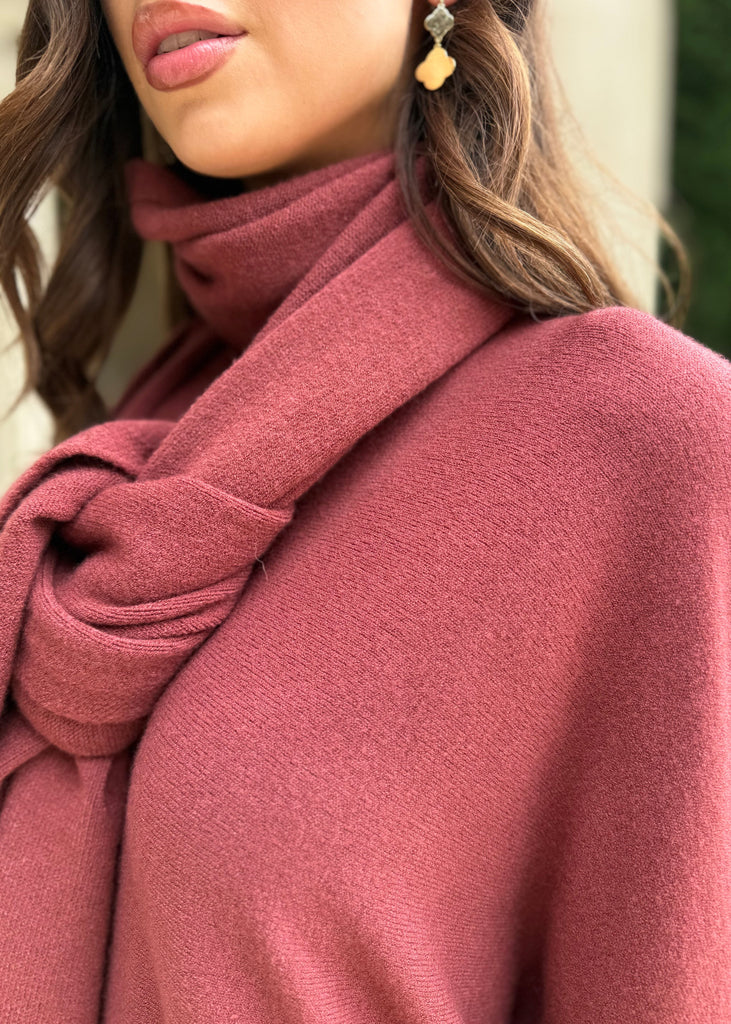 Close-up of a person wearing a pink scarf and coat with a blurred background