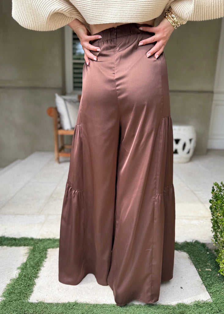 Person wearing a long brown skirt outdoors on a patio.