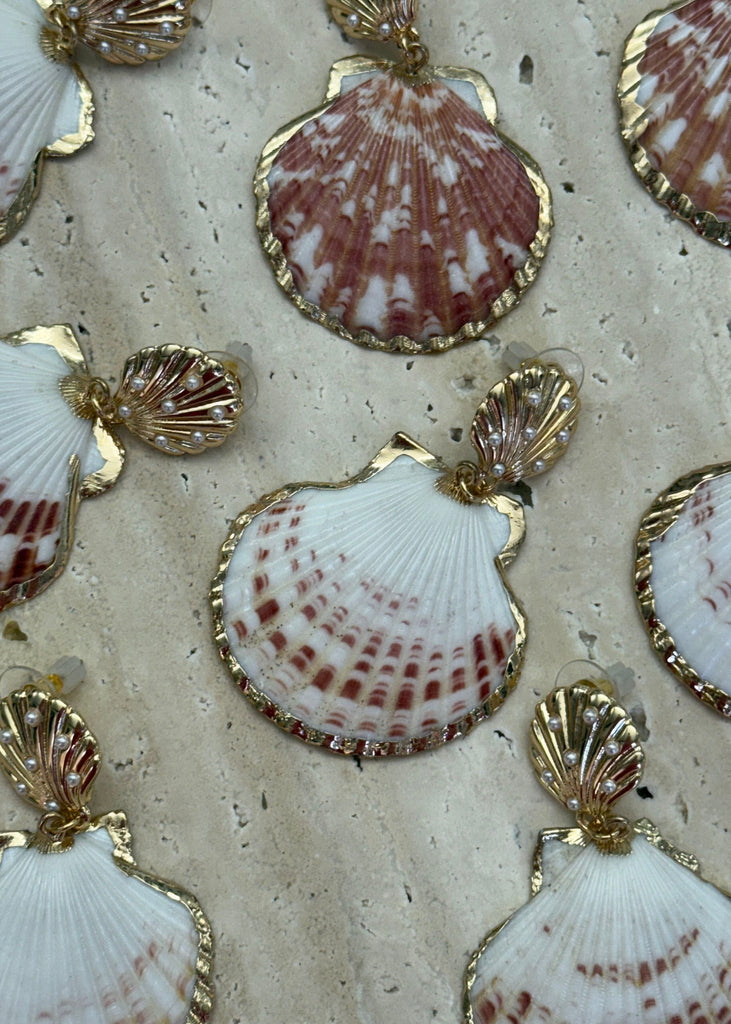 Seashell decorations with gold accents on a textured beige background