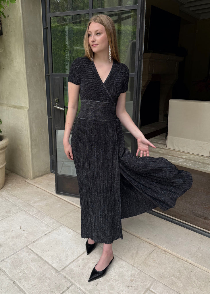 Woman in a black dress standing outside a building