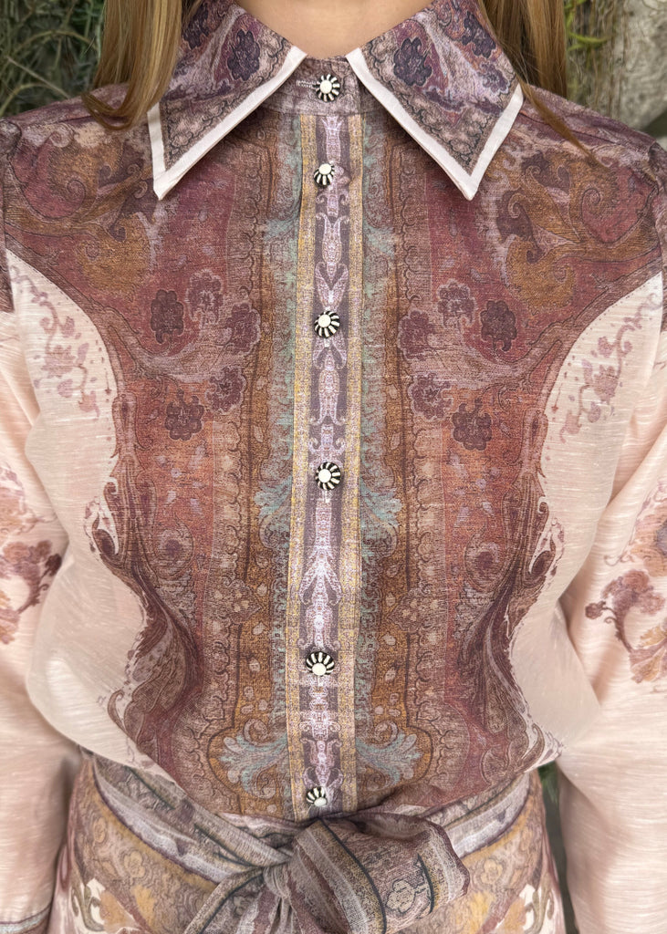 Close-up of a patterned blouse with a collar and buttons.