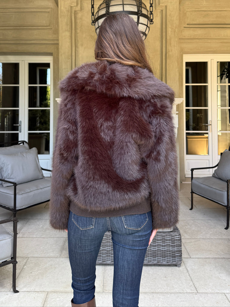 Person wearing a fur coat in a stylish interior setting