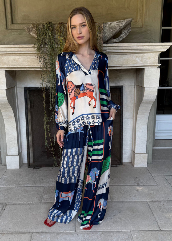 Woman wearing a colorful dress standing in front of a building entrance.