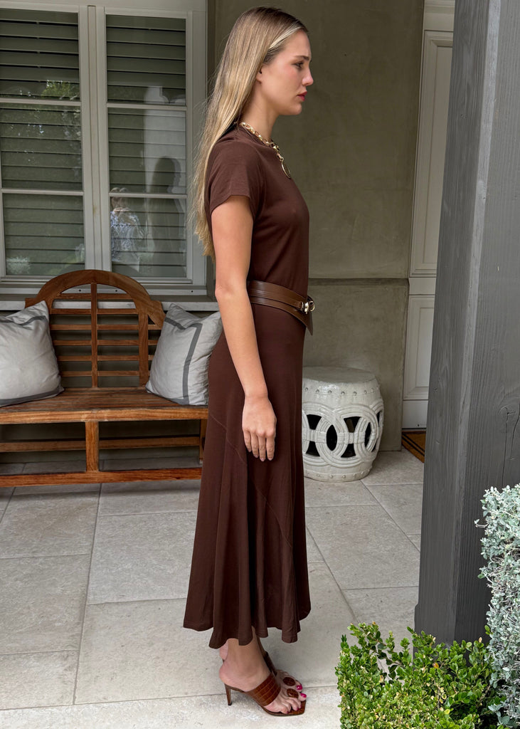 Woman in a brown dress standing on a patio