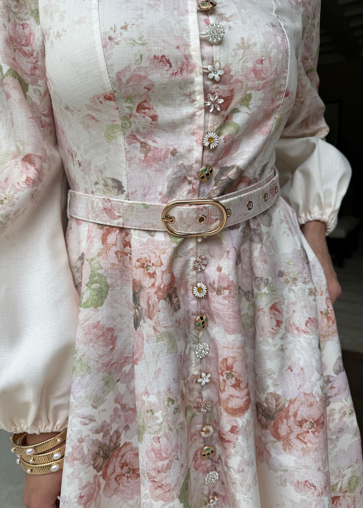 Floral dress with a belt and gold buttons on a plain background