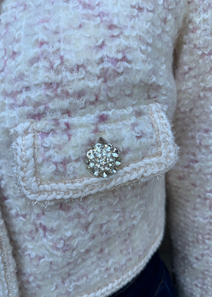 Close-up of a textured fabric with a decorative button featuring a central gemstone.