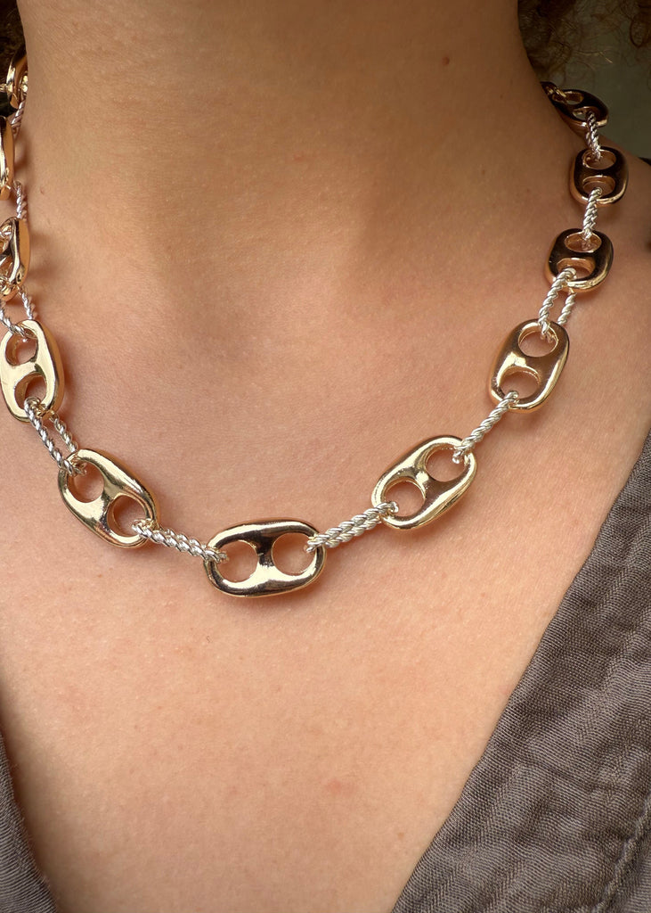 Gold and silver chain necklace on a person's neck