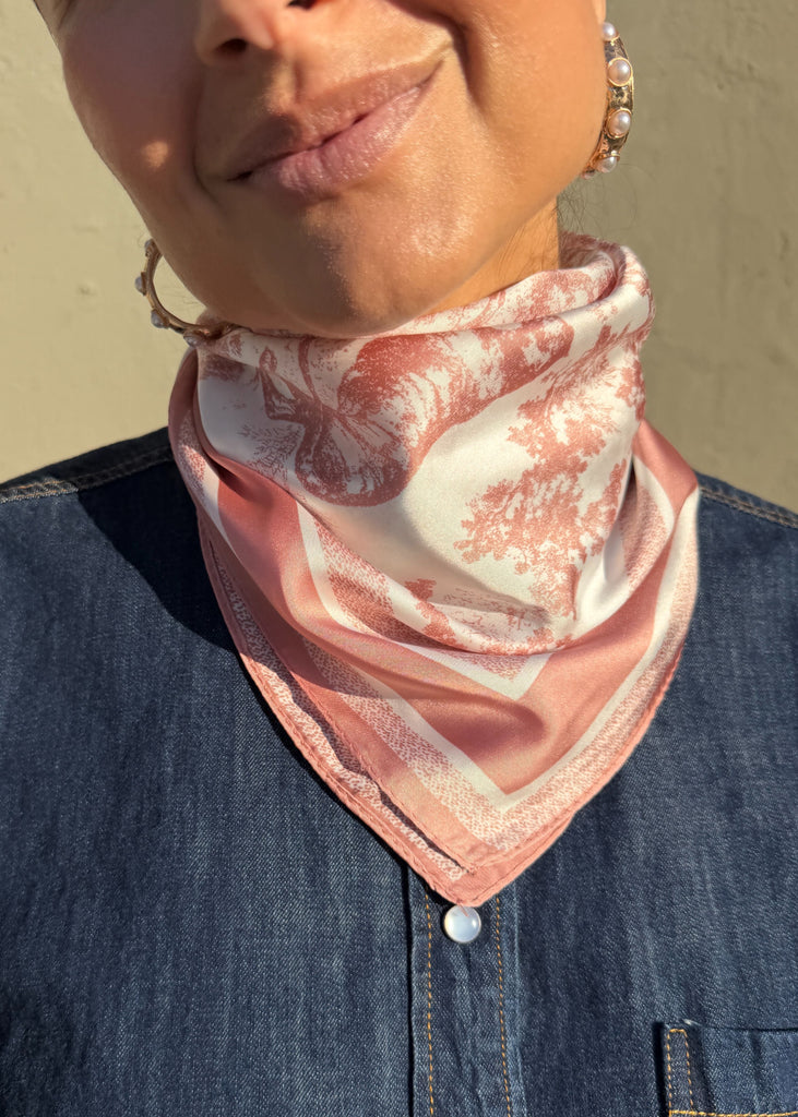 Person wearing a pink and white patterned scarf on a beige background