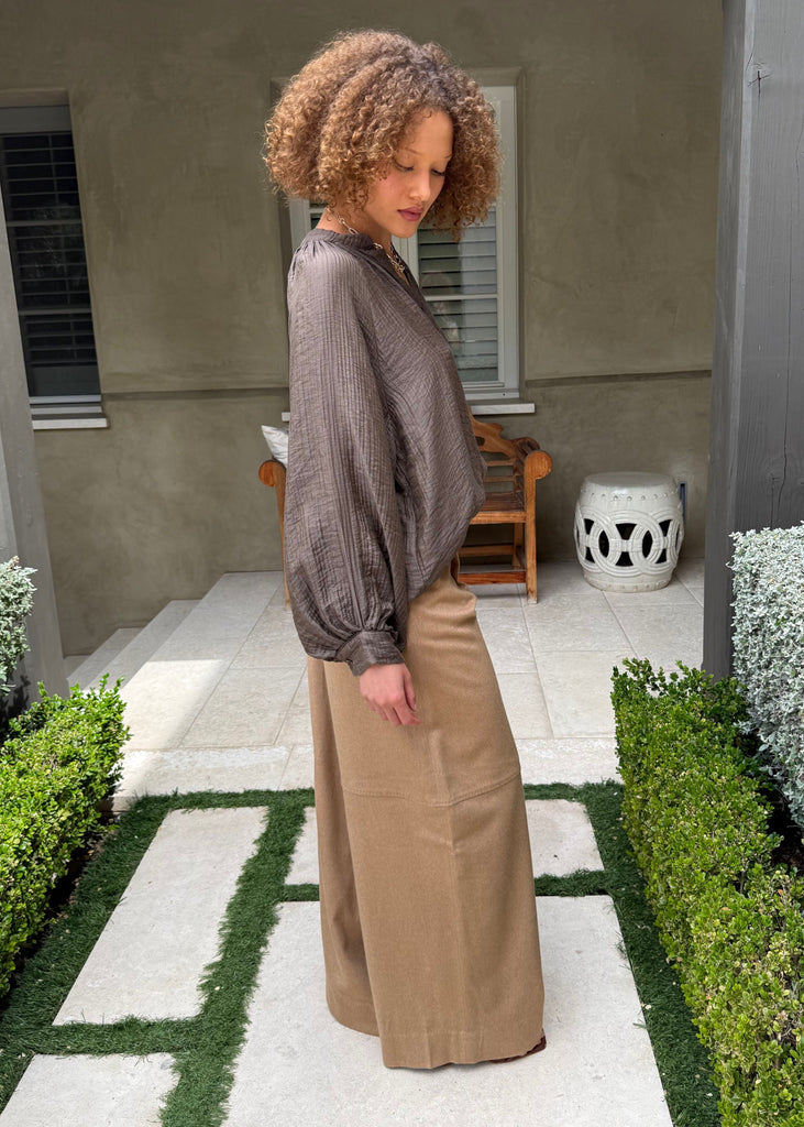 Woman standing in a garden with a house in the background