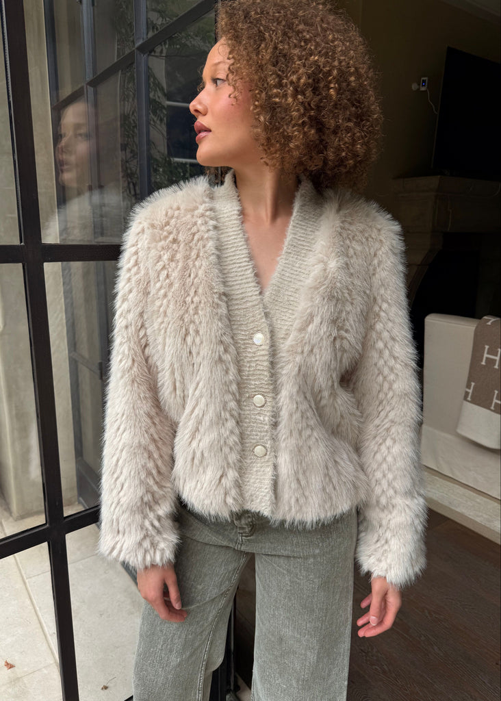 Woman wearing a fluffy white cardigan indoors