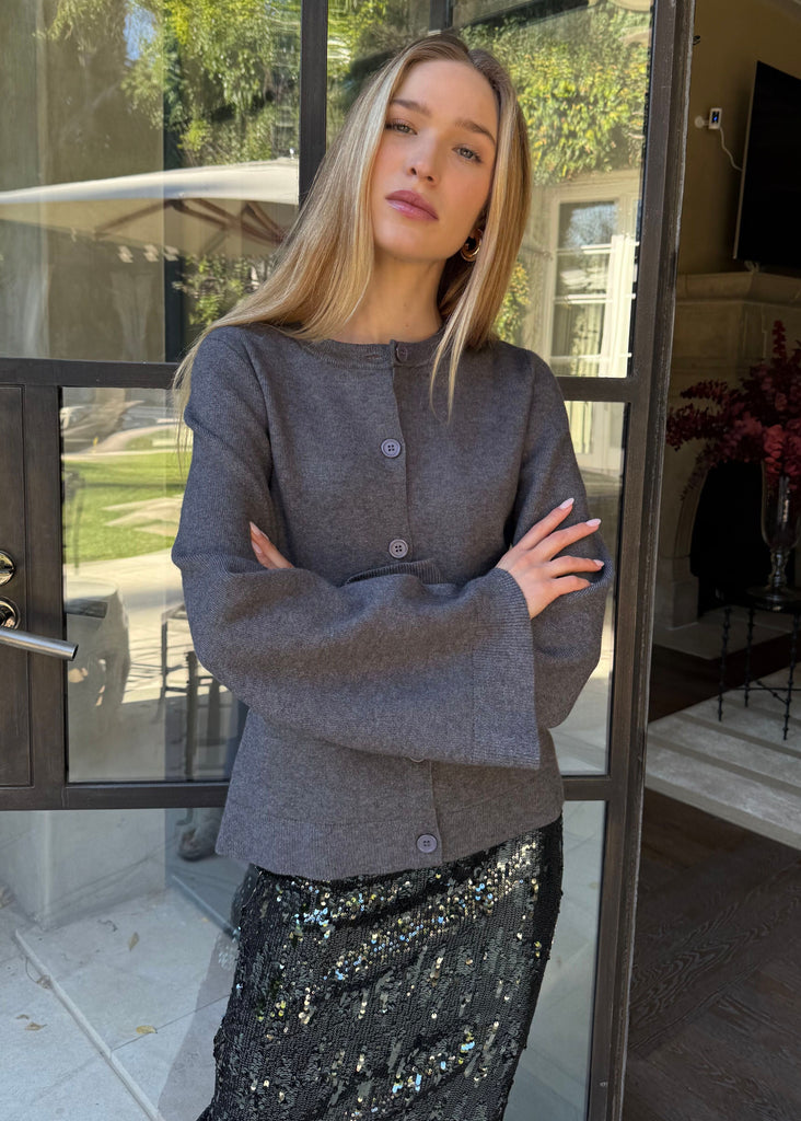 Woman standing in front of a glass door with a house exterior visible